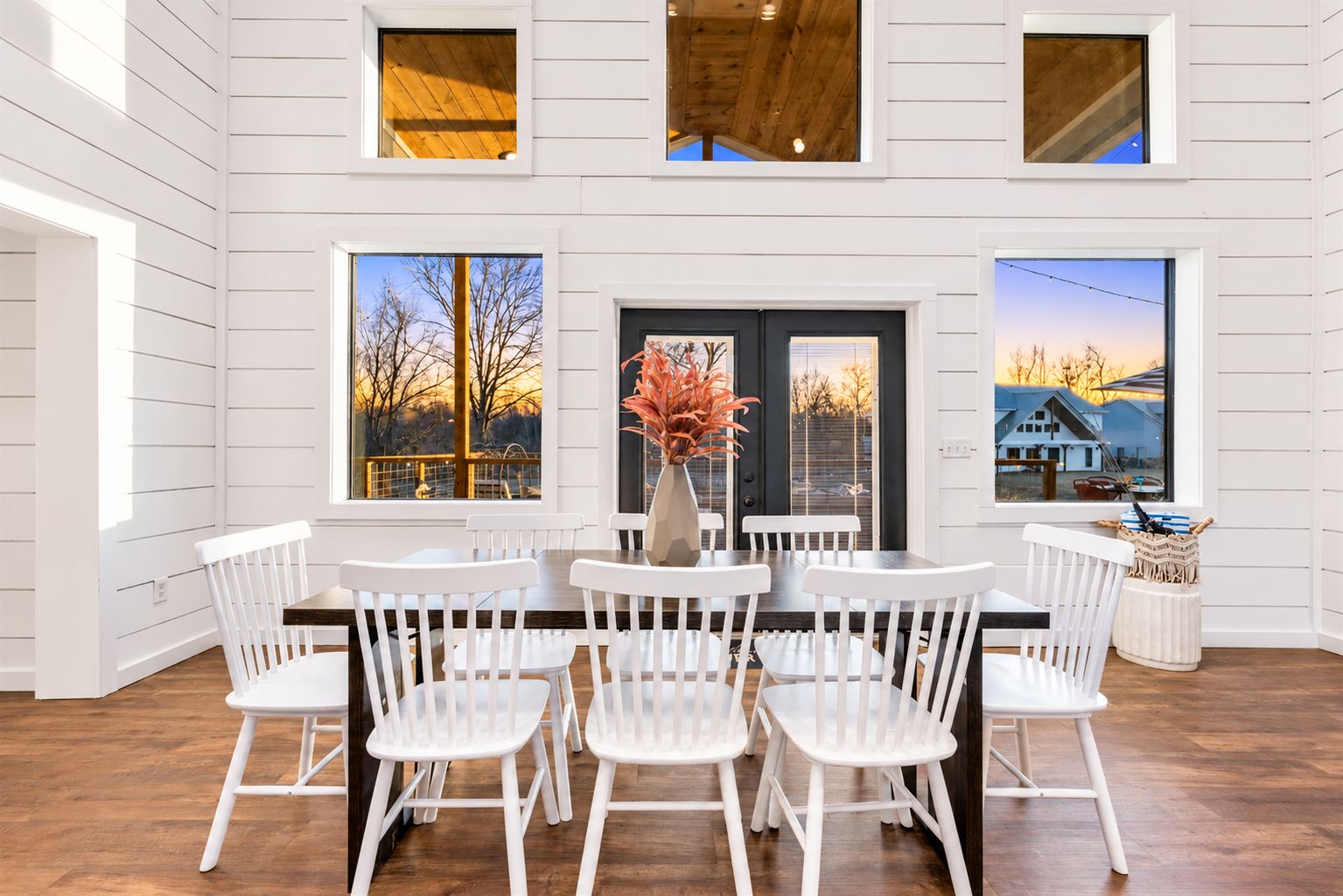 Bright dining area beneath the vaulted ceiling, surrounded by windows and outdoor views. Share leisurely meals before heading out to enjoy the riverfront setting.