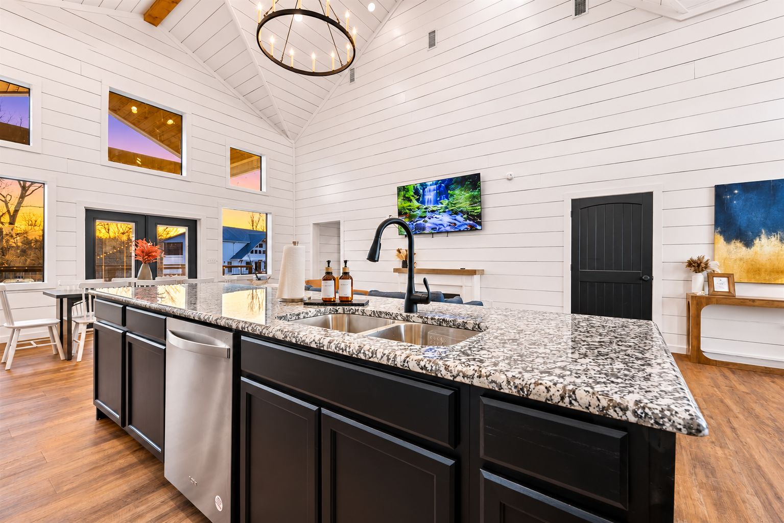 Spacious kitchen island with granite counters, sink, and stainless dishwasher opens to the living and dining areas—ideal for cooking while everyone gathers.