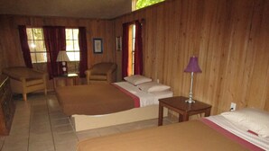 A room with two beds, a chair, a table, and a window. - The Chalet On the Suwannee River (Mayo)