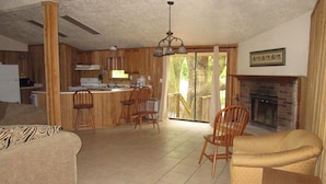 A spacious living area with a kitchen, dining area, and a fireplace. - The Chalet On the Suwannee River (Mayo)