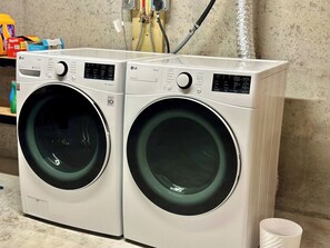 A laundry room with two white LG washing machines.