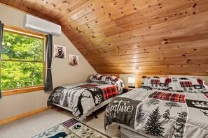 A bedroom with two beds, a window with curtains, and a ceiling with wooden beams.