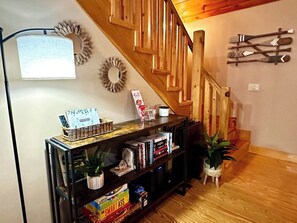 A wooden staircase with a bookcase below.