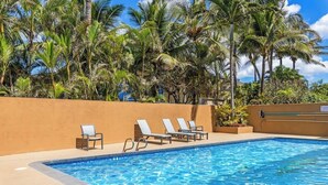A swimming pool with lounge chairs and palm trees. - Oceanview updated 1 bedroom condo, AC, 6 mile sandy beach (Kihei)