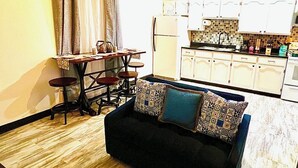 Un espace de vie compact comprenant un coin repas, une kitchenette et un ventilateur de plafond.