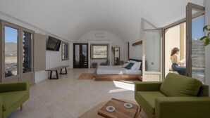 Una habitación amplia con una cama grande, un banco y vistas al exterior.