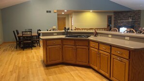 Une cuisine moderne avec des meubles en bois, un îlot central et un coin repas avec des chaises.
