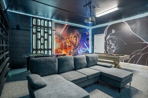 A modern lounge area with a sectional sofa, foosball table, and a pool table. - Stunning 10 Bed Home With Themed Rooms Pool (Clermont)