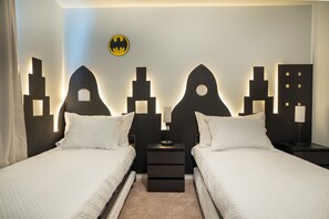 A hotel room with two beds, a Batman logo on the wall, and a cityscape design. - Stunning 10 Bed Home With Themed Rooms Pool (Clermont)