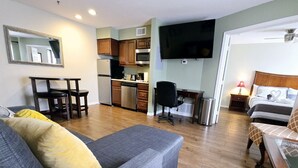 A compact living space with a kitchenette, a sofa, a bed, and a TV. - King Bed First Floor Disney Universal Family Condo (Kissimmee)
