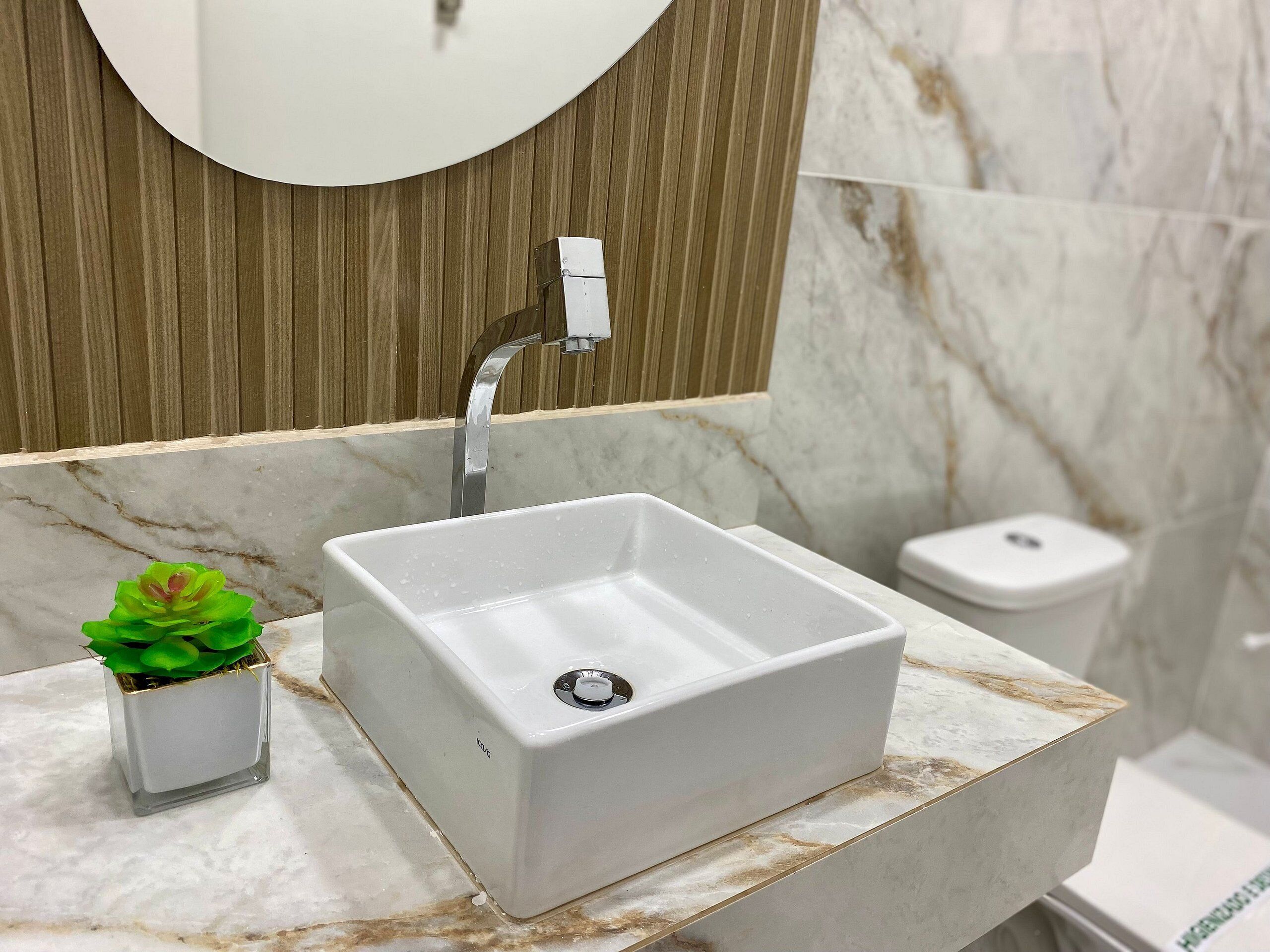 Une salle de bain avec un lavabo blanc, un miroir et des toilettes.