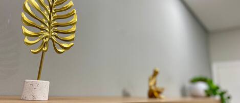 A shelf with a golden decorative leaf and a small figurine.