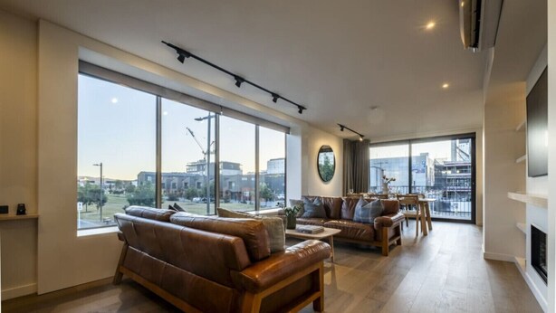 Amplia sala de estar con ventanas grandes, chimenea y vistas a la ciudad.