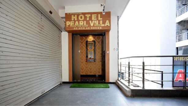A hotel entrance with a sign reading "HOTEL PEARL VILLA AC NON AC ROOMS". - Pearl Villla Hotel (Gandhinagar)