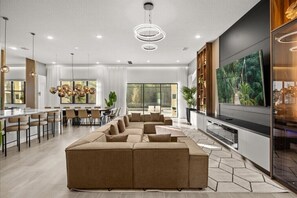 Relax in a spacious living area with a large sectional sofa, dining table, and flat-screen TV.