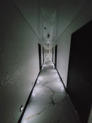 A long, narrow hallway with a marble floor and recessed lighting. - Antares (Shemonaikha)