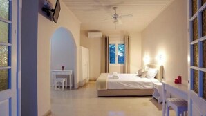 Quarto com cama, mesa de cabeceira e escrivaninha com cadeira.