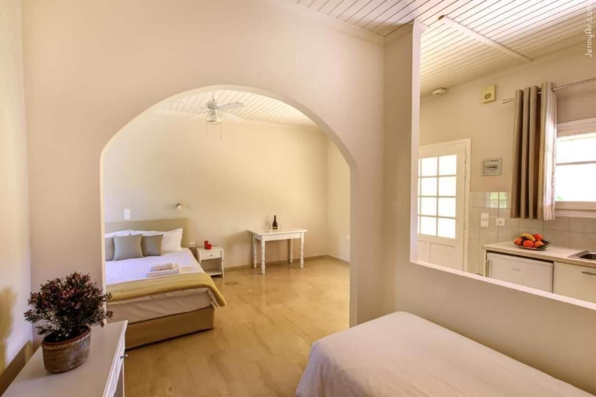 A bedroom with a bed, bedside table, and a potted plant.