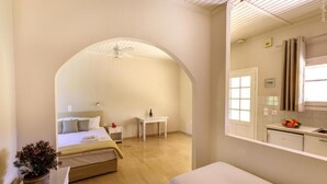 A bedroom with a bed, bedside table, and a potted plant.