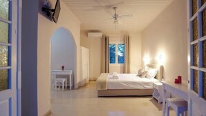 A bedroom with a bed, bedside table, and a desk with a chair.