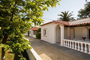 Calle residencial con casas de techos de tejas, paredes blancas y balcones.