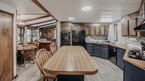 A modern kitchen with wooden cabinets, a central island, and built-in appliances. - Welcome to The Baker House Retreat - The Ranch House and The Bunk House (Maple Falls)