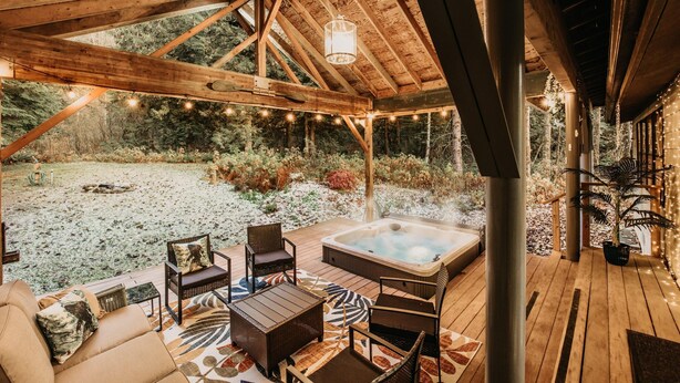 A wooden deck with outdoor seating, a hot tub, and string lights. - Welcome to The Baker House Retreat - The Ranch House and The Bunk House (Maple Falls)