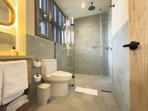 Un baño moderno con inodoro, lavabo y ducha.