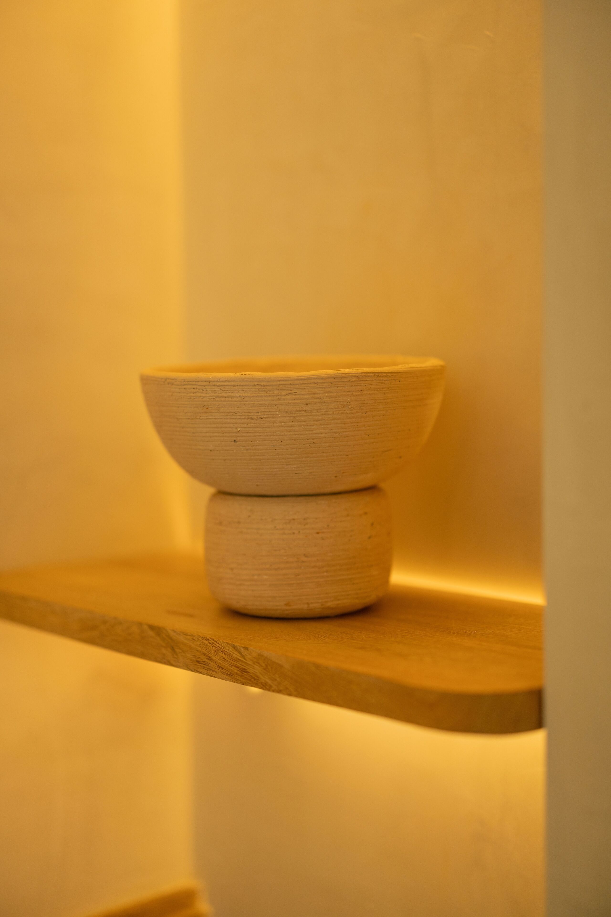 Una estantería de madera con dos cuencos apilados.