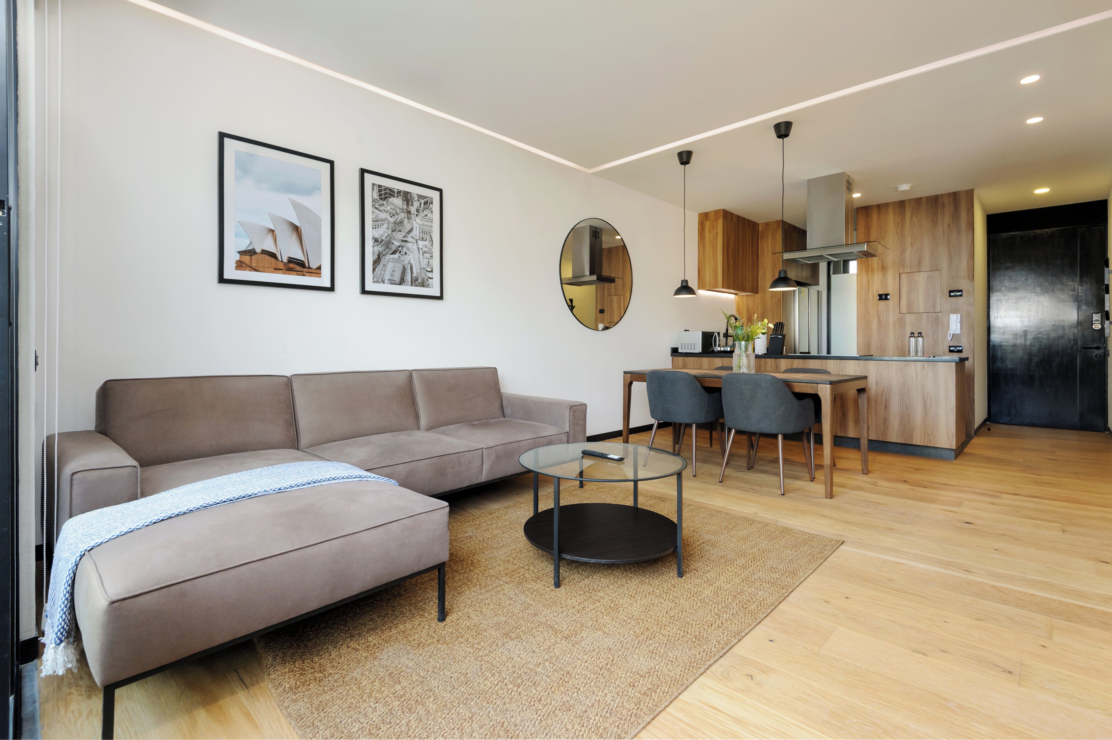 Uma sala de estar moderna com sofá, mesa de centro e área de jantar.