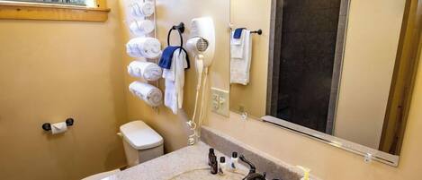 A bathroom with a sink, toilet, towel rack, and a mirror.