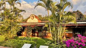 Un resort con un patio que cuenta con sillones de descanso y una pequeña mesa con un farol.