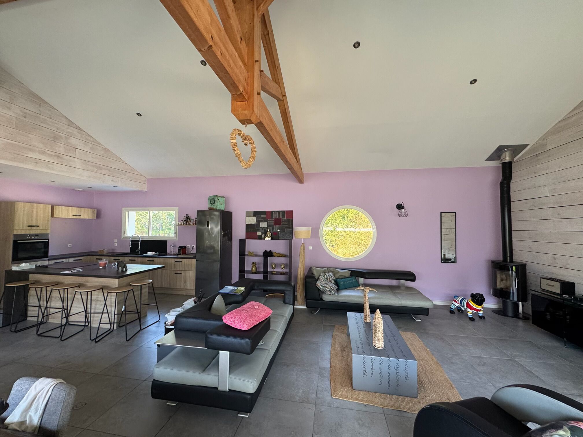 A modern living space with a kitchen, dining area, and seating area.