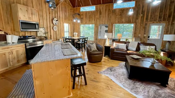 A spacious cabin interior with a kitchen, dining area, and living room.