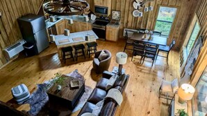 A spacious cabin interior with a dining area, kitchen, and seating area.