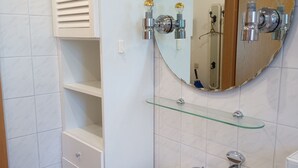 A bathroom with a white sink, a glass shelf, a mirror, and a towel rack. - Hexenstube Morgana Romantic apartment by the national park WLAN Pet-friendly, (Braunlage)