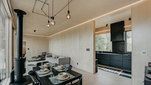 Uma cozinha moderna com armários escuros, um fogão grande e uma área de refeições com mesa posta para quatro pessoas.