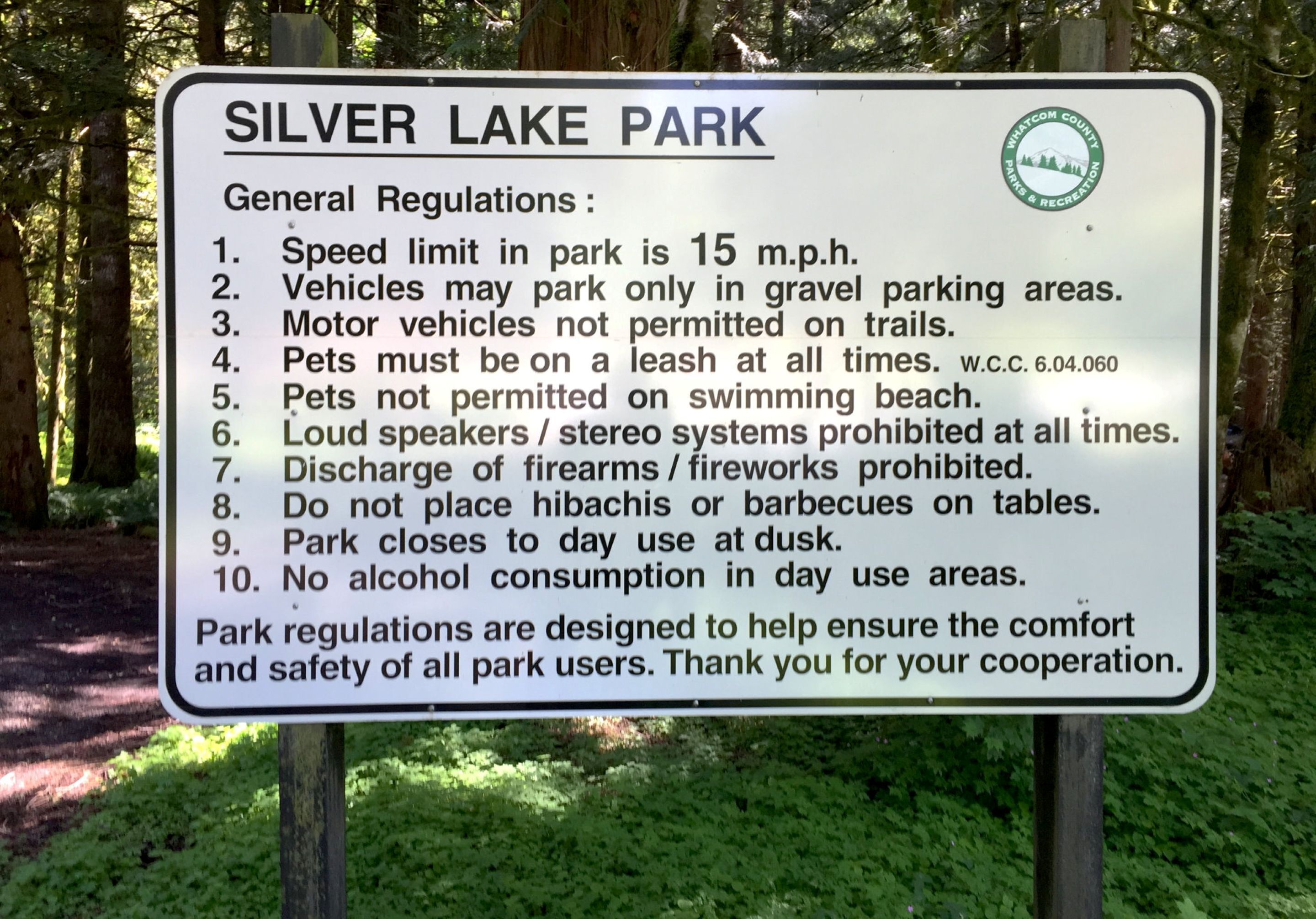 A sign listing general regulations for Silver Lake Park, including speed limits, pet policies, and no alcohol consumption.
