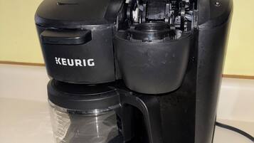Een zwarte Keurig koffiezetapparaat met een transparante waterreservoir en een drip tray.