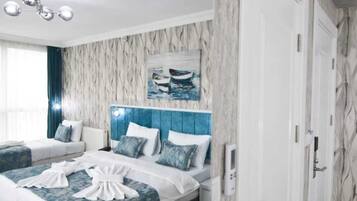 Habitación de hotel con una cama, una mesita de noche, un cuadro colgado en la pared y una puerta.