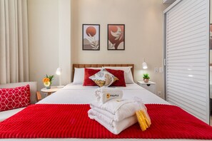 Relax in a stylishly designed room with a comfortable bed, framed artworks, and a potted plant.