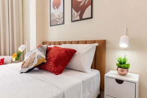 Cozy retreat with a comfortable bed, bedside table, and artwork.