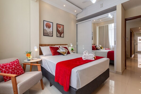 Relax in a stylish room with a large bed, nightstands, and a spacious area with a mirror.