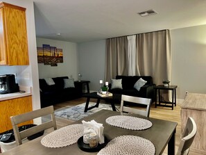 Relax in this stylish living room with a sofa, coffee maker, and dining table.