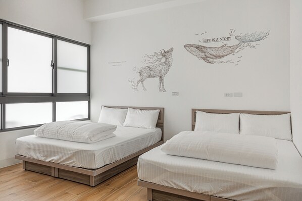 Un dormitorio con dos camas, un ventanal grande y una obra de arte en la pared que representa un ciervo y la frase 'LIFE IS A STORY'.