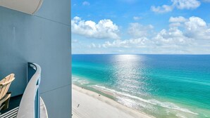 A balcony with a view of a beach and ocean.