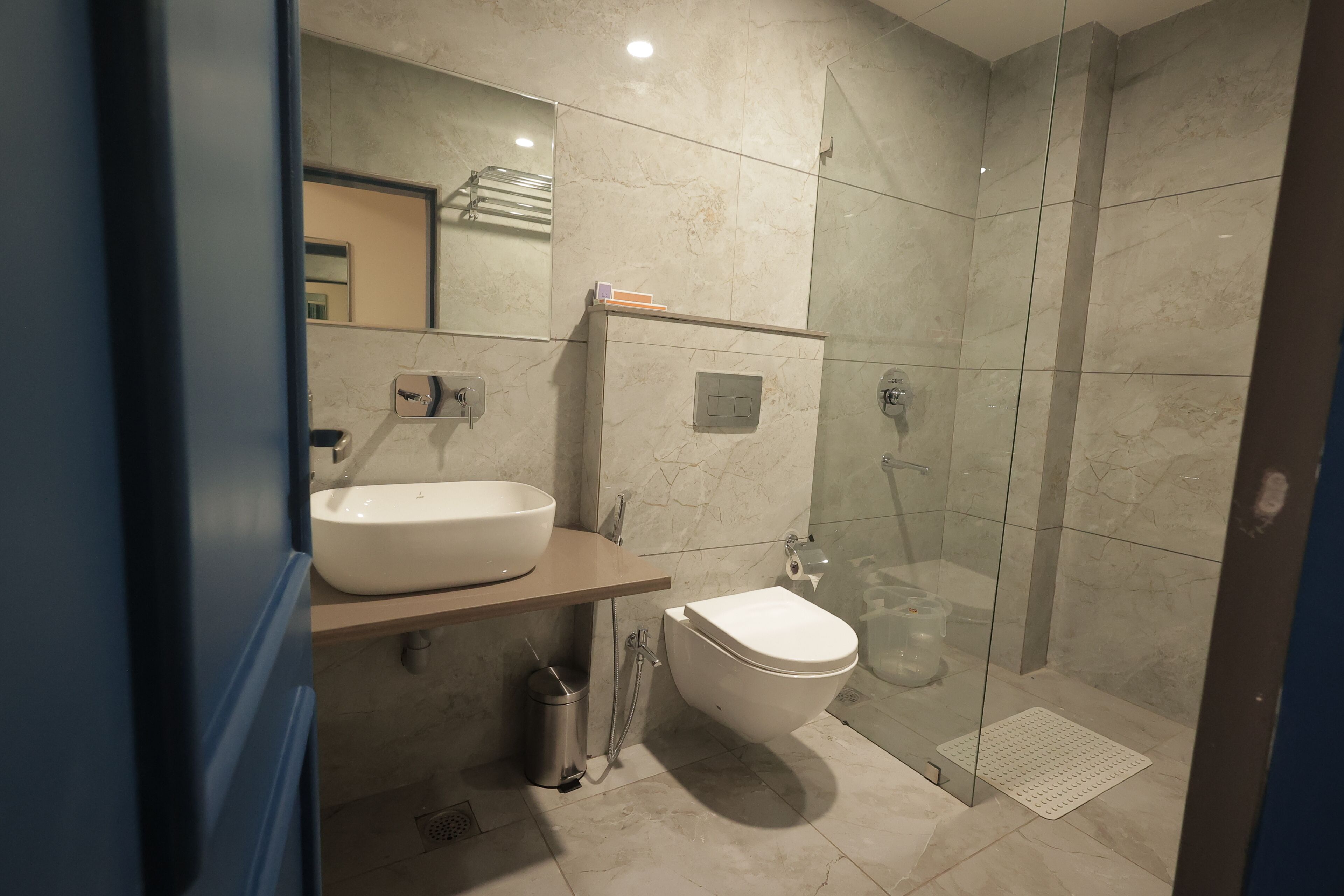 A bathroom with a sink, toilet, and glass-enclosed shower.