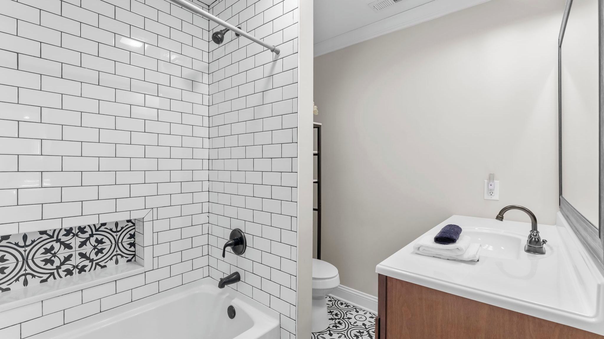 Ein Badezimmer mit einer weißen Badewanne, einer Dusche und einem Waschbecken mit Spiegel.