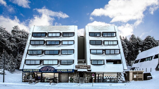 A multi-story building with signs for 'Location Surfs' and 'Location Skis'. - Les Lupins - Station de ski à pied (Eyne)