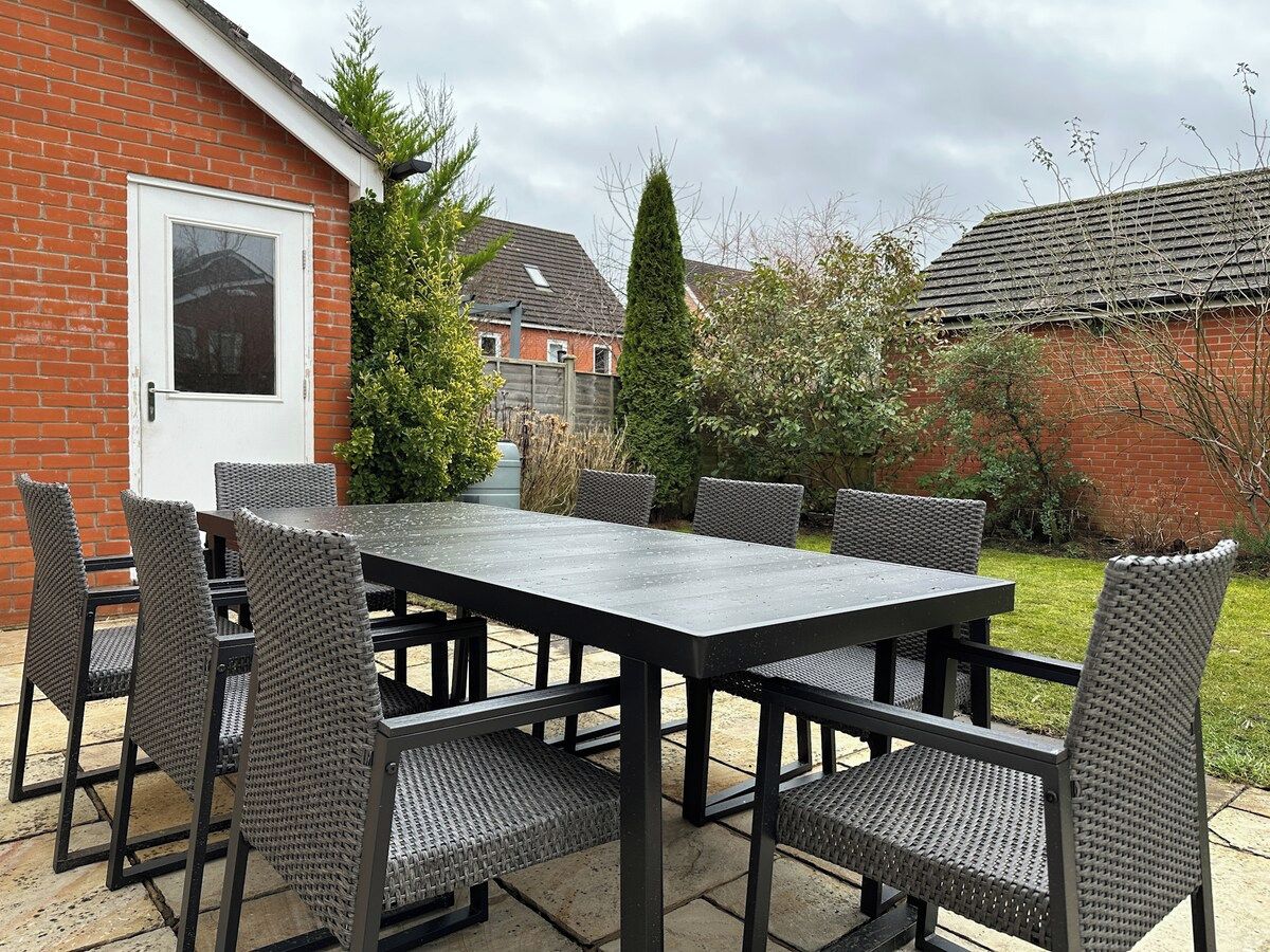 An outdoor patio with a rectangular table and six chairs.